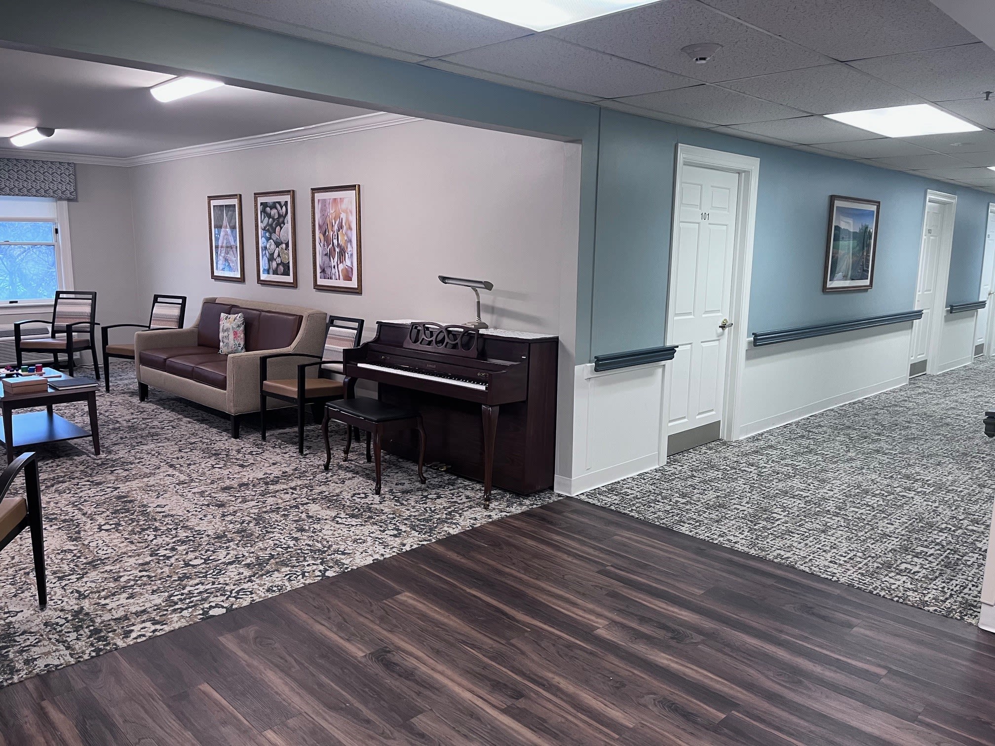 Senior living lounge with piano and hallway