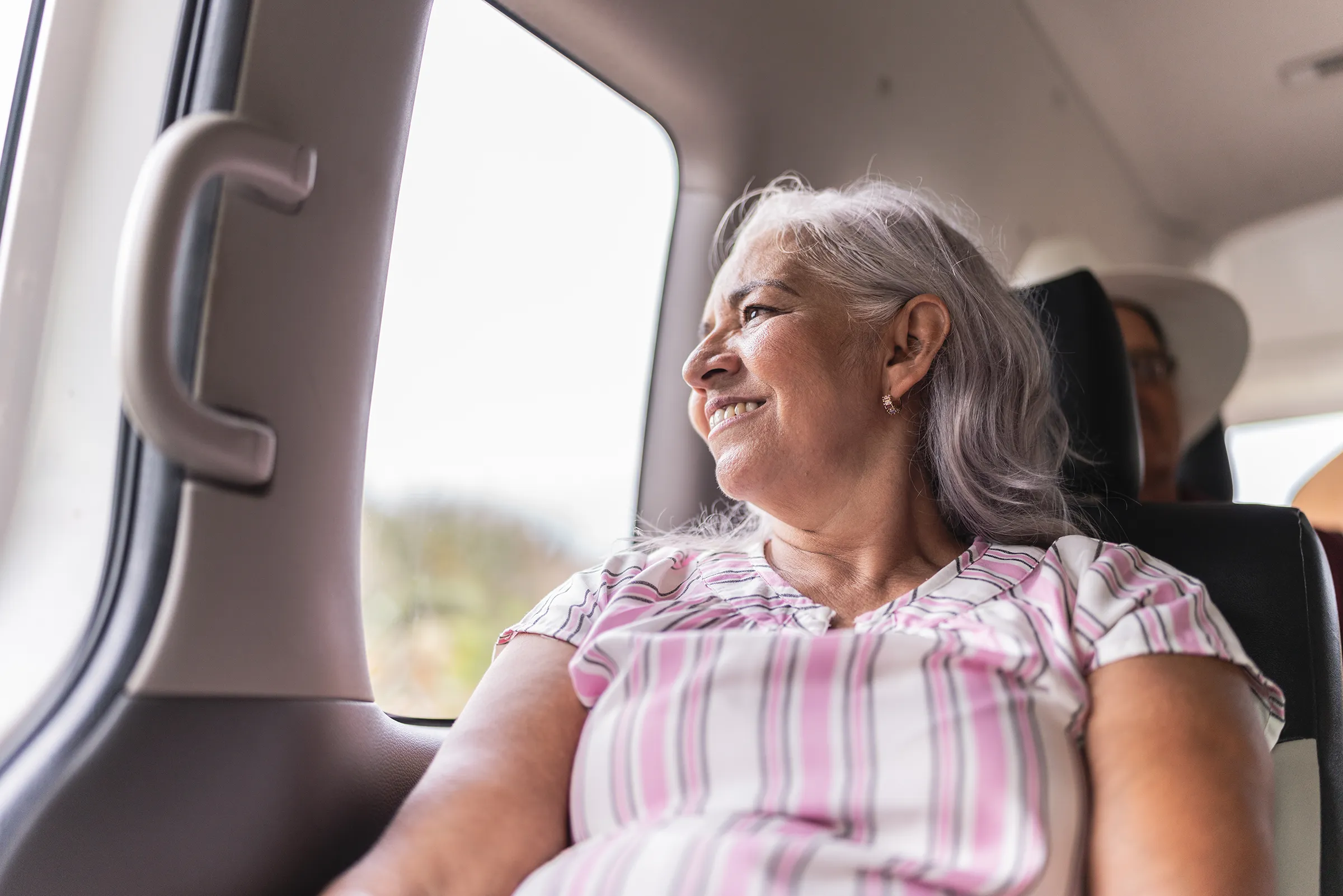 Smiling senior woman looking out train window